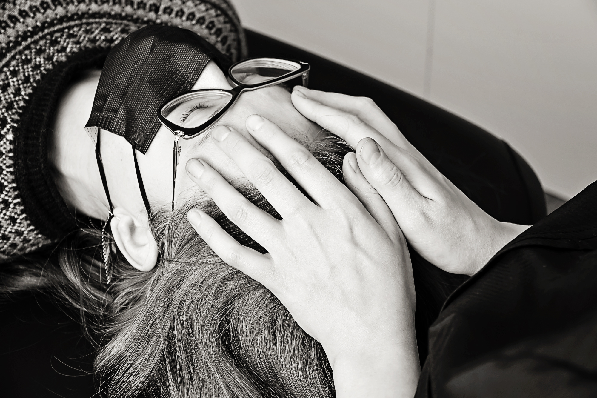 woman has hands on her forehead during craniosacral therapy appointment